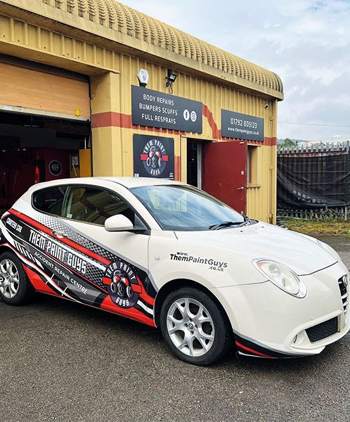 A car featuring the red and white Them Paint Guys logo and branding with "Accident Repair Centre" wording emphasising its courtey car usage