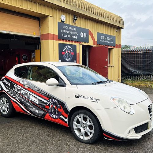 A car featuring the red and white Them Paint Guys logo and branding with "Accident Repair Centre" wording emphasising its courtey car usage