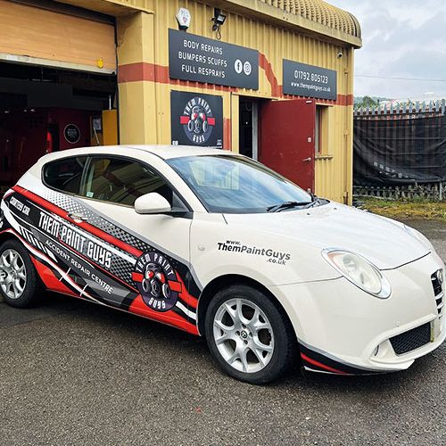 A car featuring the red and white Them Paint Guys logo and branding with "Accident Repair Centre" wording emphasising its courtey car usage