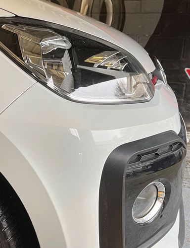A small white car looking shiny following a bumper section repair at Them Paint Guys Vehicle Body Shop in Pontardawe, Swansea
