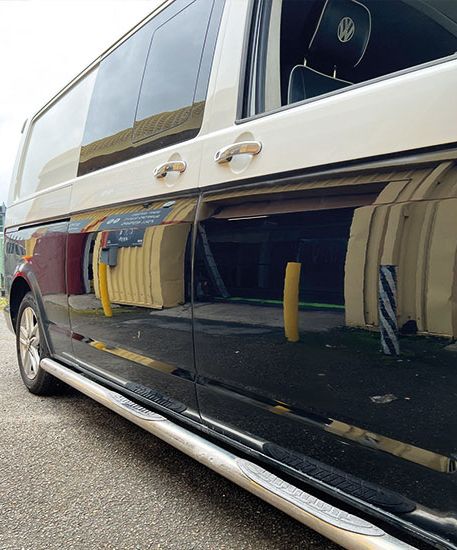 A two-tone VW Transporter outside Them Paint Guys Vehicle Body Shop following fibreglass bodywork repairs