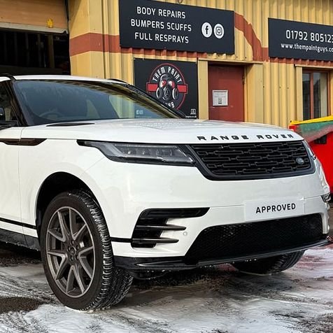 A white Range Rover parked outside Them Paint Guys Vehicle Repair bodyshop in Pontardawe, Swansea, freshly cleaned following repair