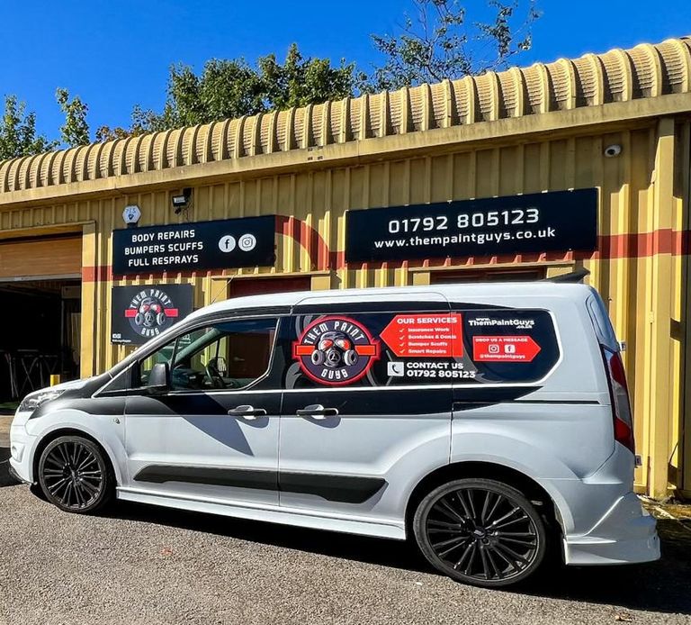 A signaged vehicle showing Them Paint Guys red and white logo and branding parked outside the Vehicle Body shop based in Pontardawe, Swansea